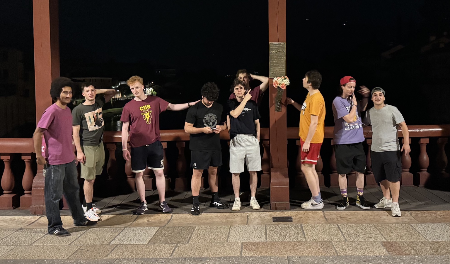 CUS Padova teammates together on the covered bridge in Bassano del Grappa at night.