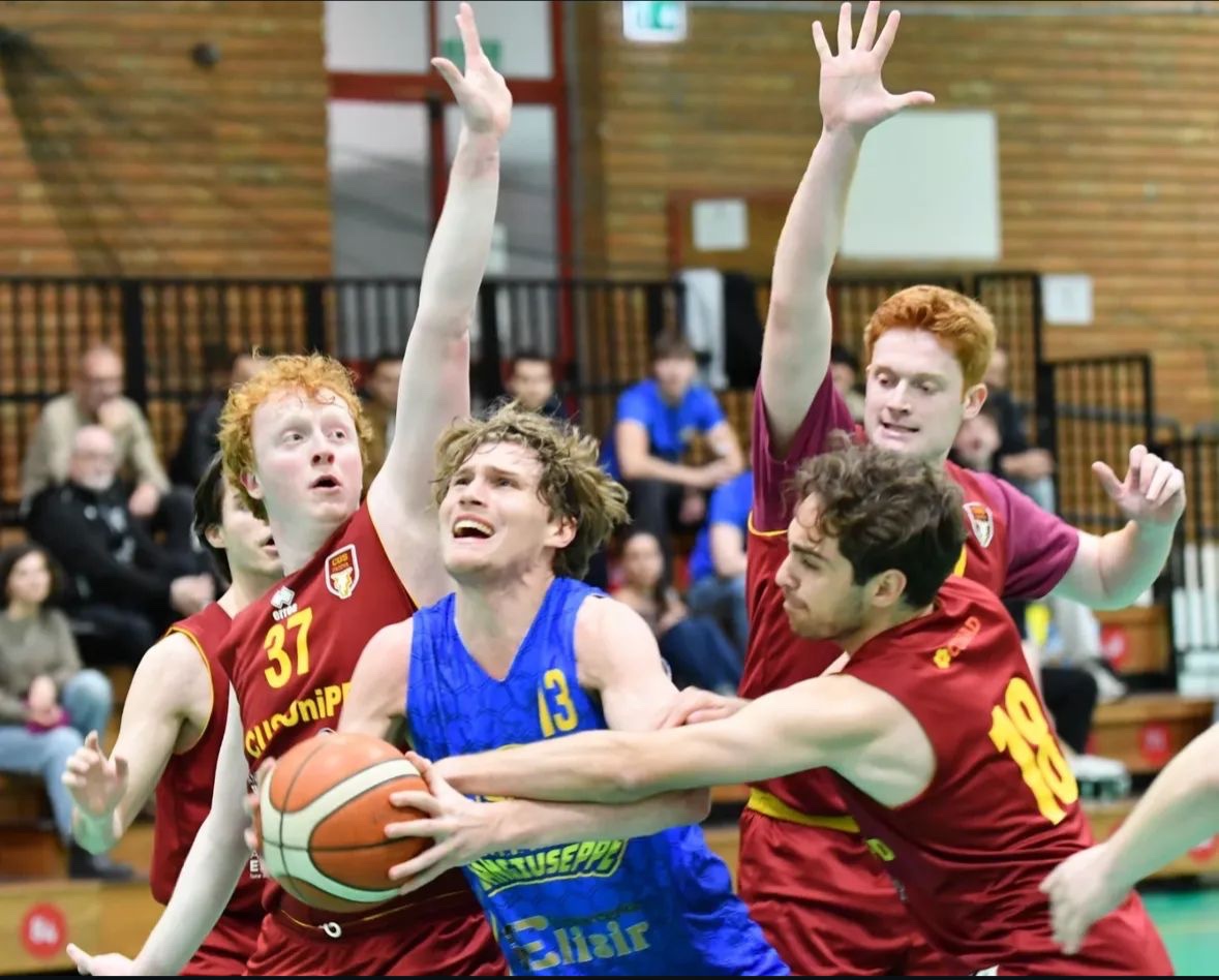 CUS Padova players in amaranto defending an opponent with the ball near the basket.