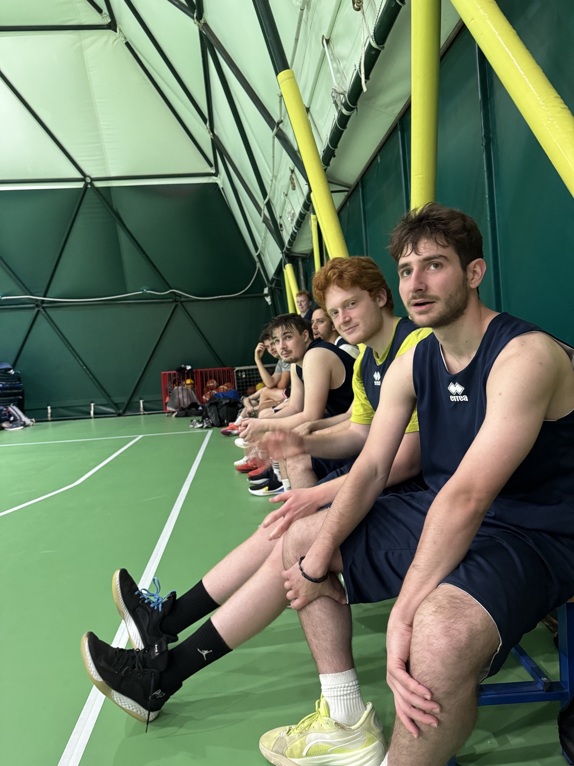 CUS Padova teammates seated along the sideline bench.